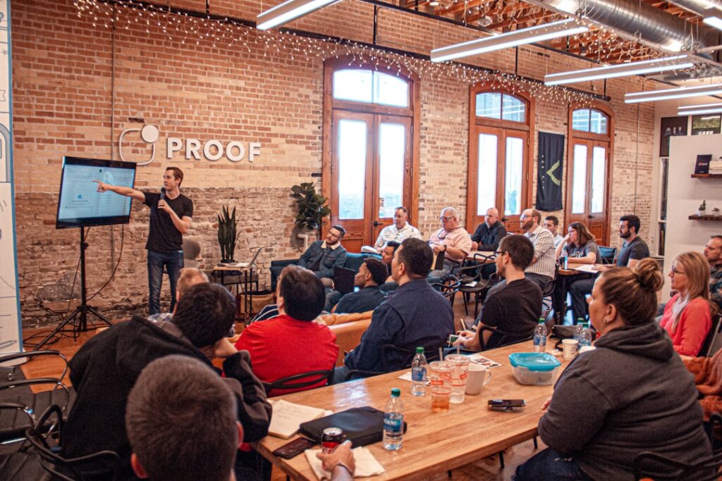 Man presenting to a small audience in a startup office