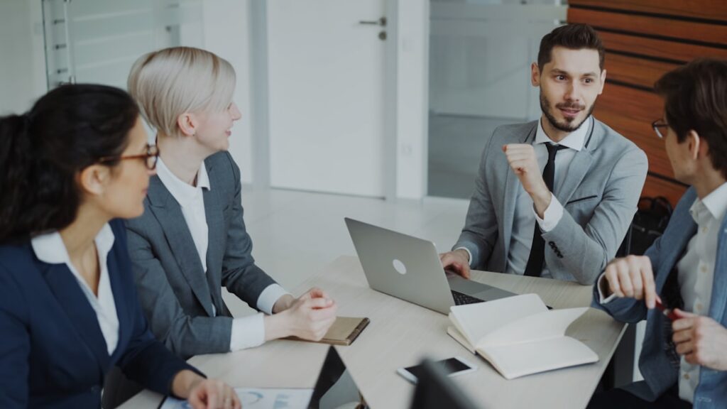 Business professionals in a meeting discussing sales strategy around a table