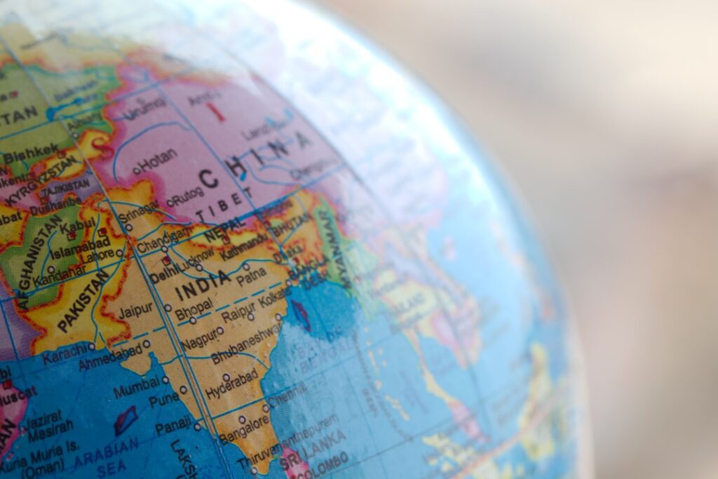 Blue and brown world map globe representing international AI geopolitics and cross-border business