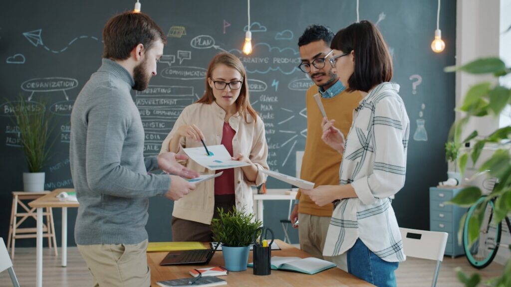 Diverse team collaborating on business strategy with charts and graphs