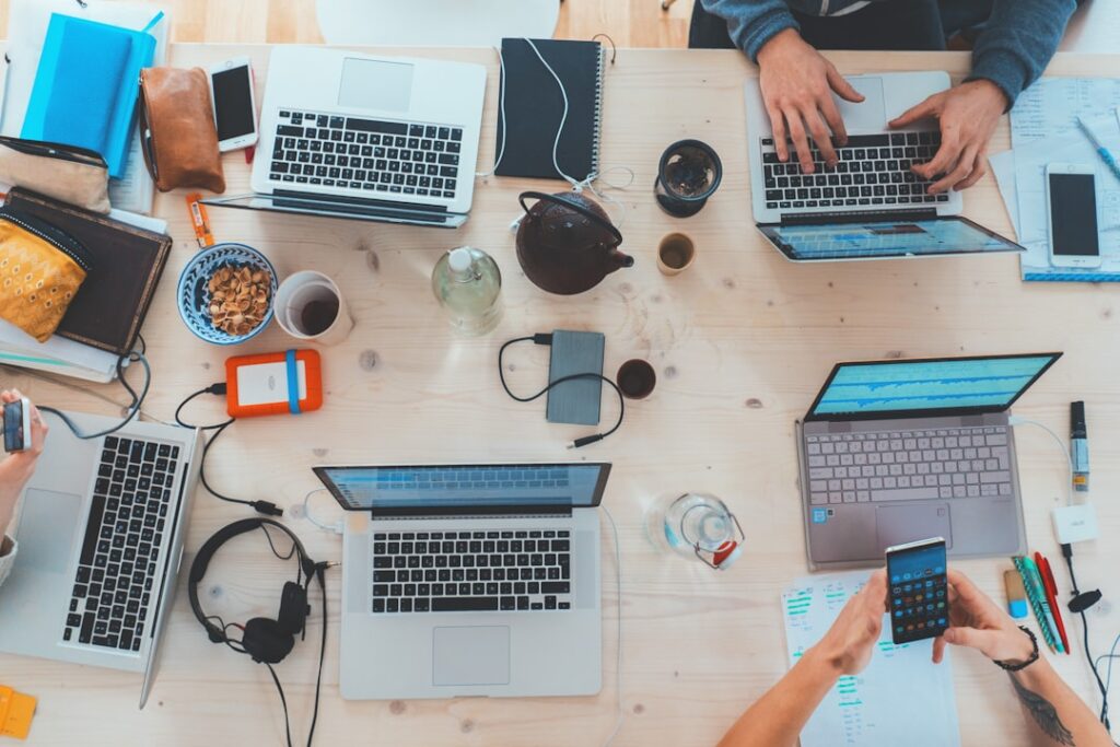 Team working together at a table with multiple laptop computers