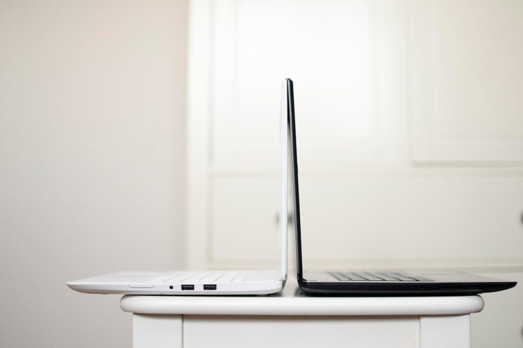 Two laptops placed back to back on a table representing a business technology comparison